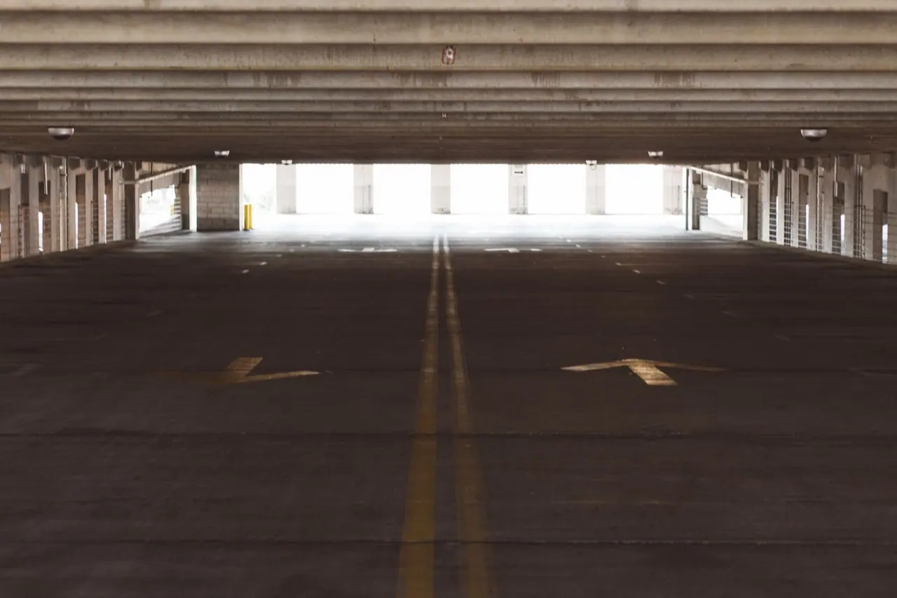 An empty parking garage level with painted arrows on the floor