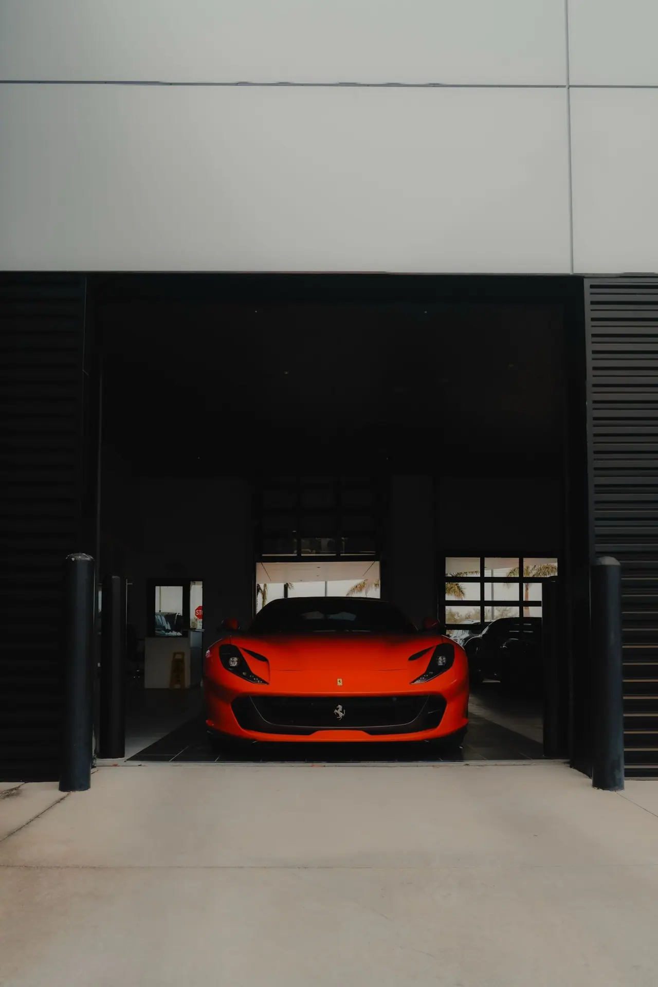 A red sports car parked inside a modern garage